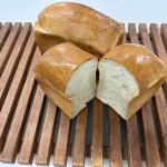 グランディールジャポネの米粉の食パン。手前のパンは縦に割られ、白い内層が見える。