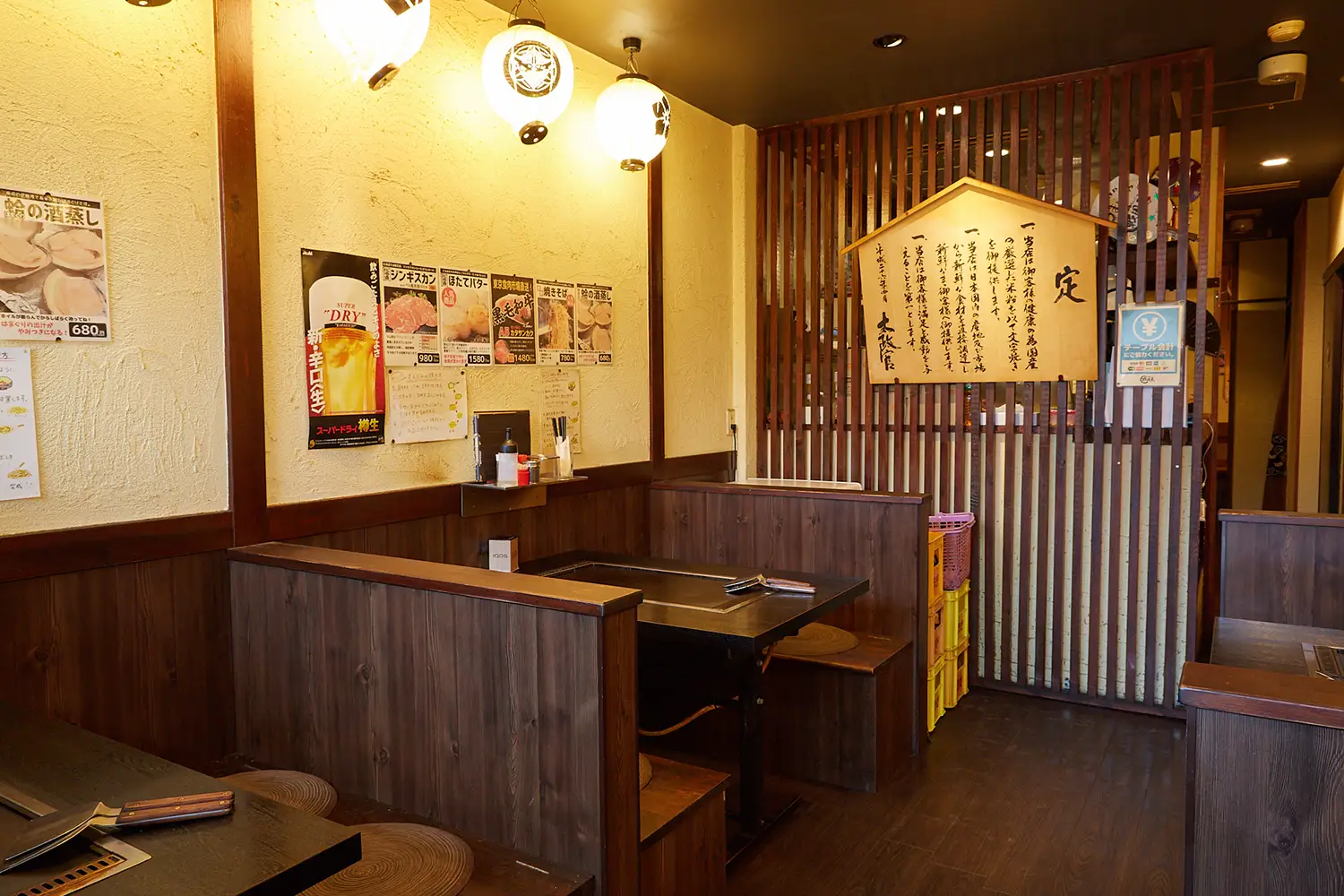 米粉もんじゃ 戦国屋の店内。仕切りに囲まれた掘りごたつ式の座席と、壁に貼られたメニューやポスターがみえる。